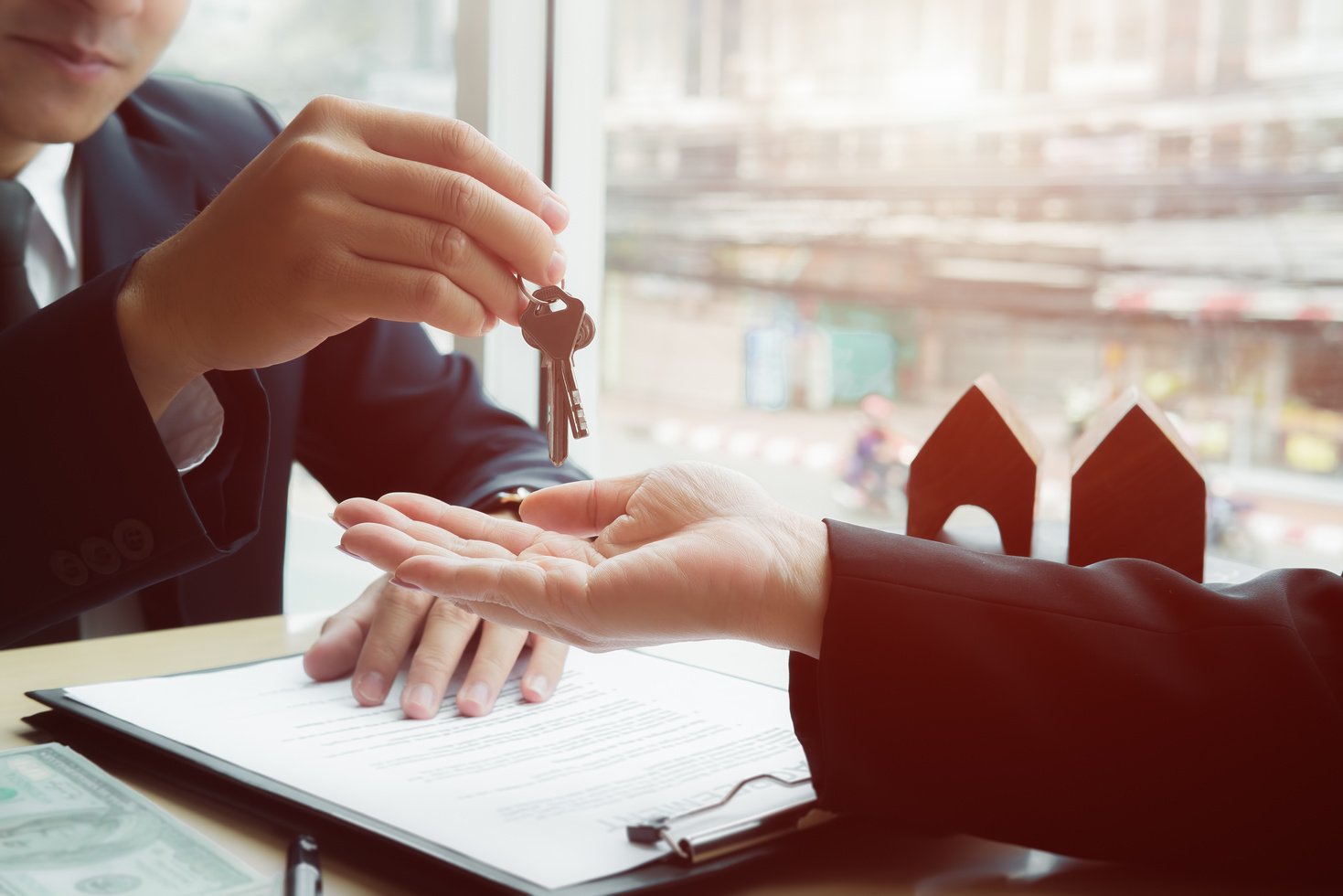 Real Estate Agent Holding House Key to His Client 